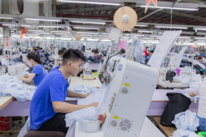 Công nhân may mặc thao tác trên máy móc trong dây chuyền sản xuất